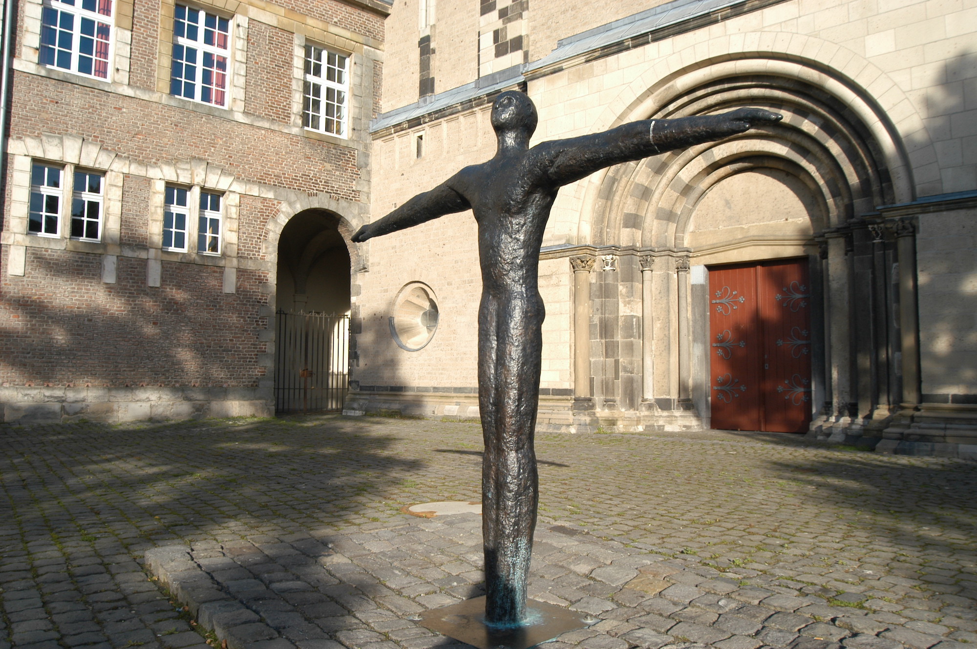 Die Skulptur „Mensch mit ausgestreckten Armen“ von Maria Lehnen steht auf dem Münsterplatz. Sie wendet ihr Gesicht der untergehenden Sonne im Westen zu. (c) Garnet Manecke