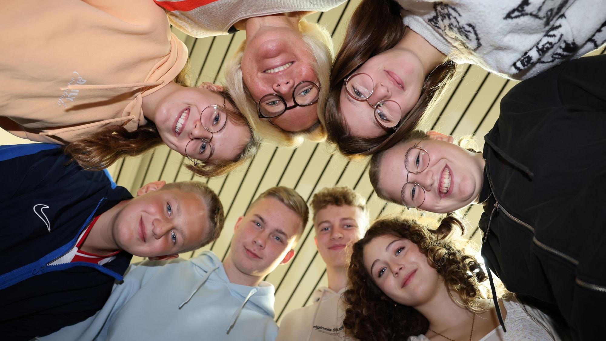 Lehrerin Stephanie Reuter (oben, Mitte, umgeben von Schülerinnen und Schülern) hat das Patenprojekt „Jung und Alt“ ins Leben gerufen. (c) Stephan Johnen