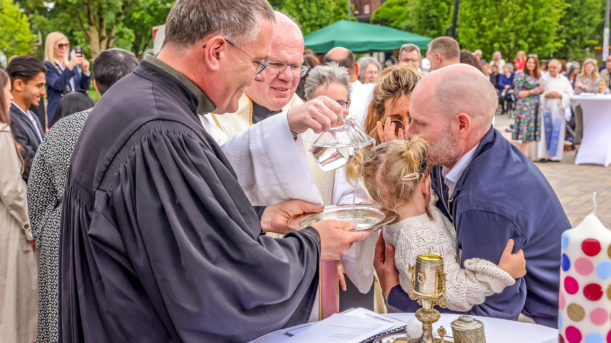 Während Regionalvikar Ulrich Clancett das Sakrament spendet, hält sein evangelischer Kollege Till Hüttenberger die Taufschale. (c) Bistum Aachen/Andreas Steindl