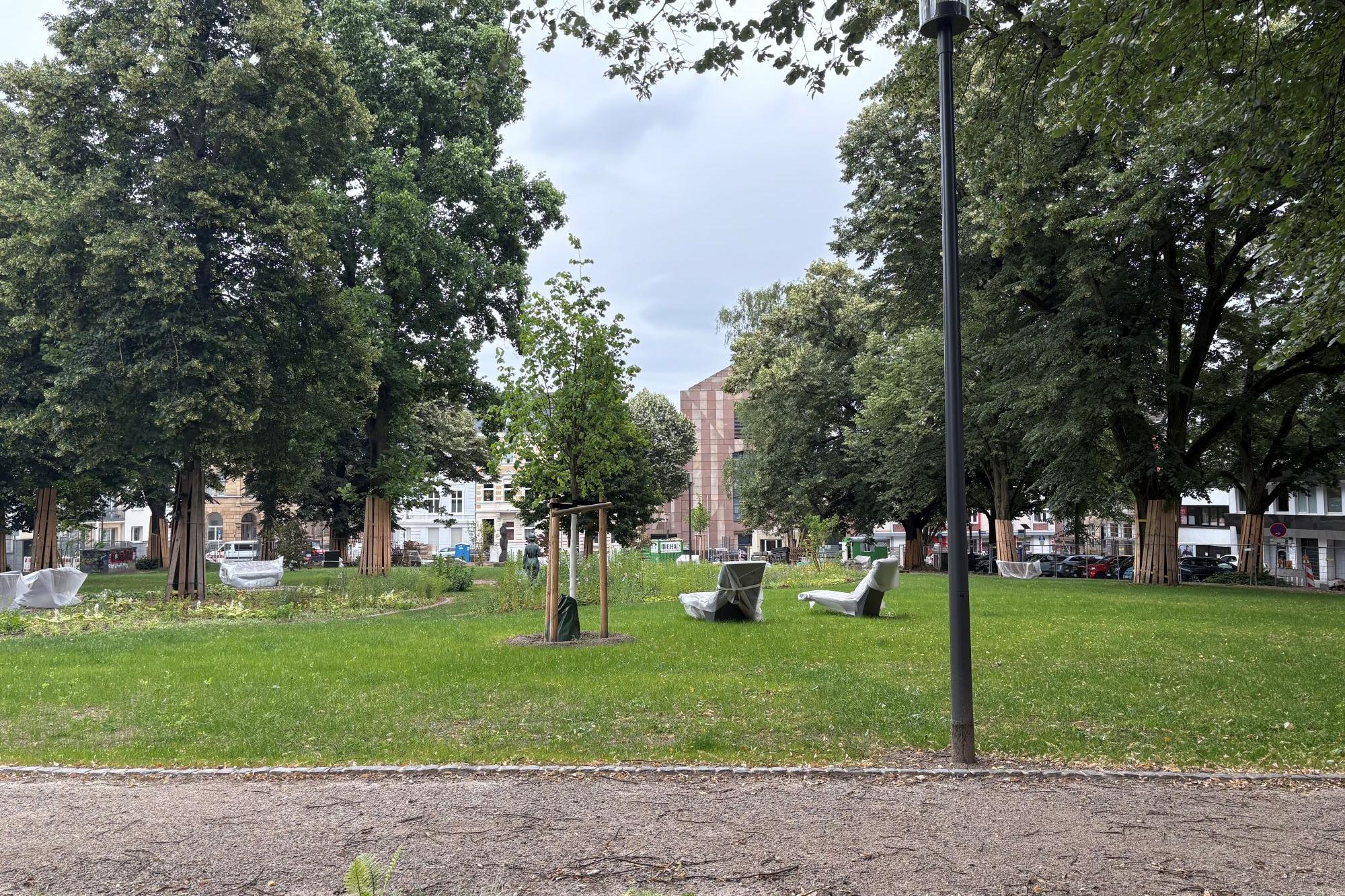 Die Grünanlage des Adenauerplatzes wird derzeit neu gestaltet. Im hinteren Teil des Bildes ist die Albertuskirche erkennbar.