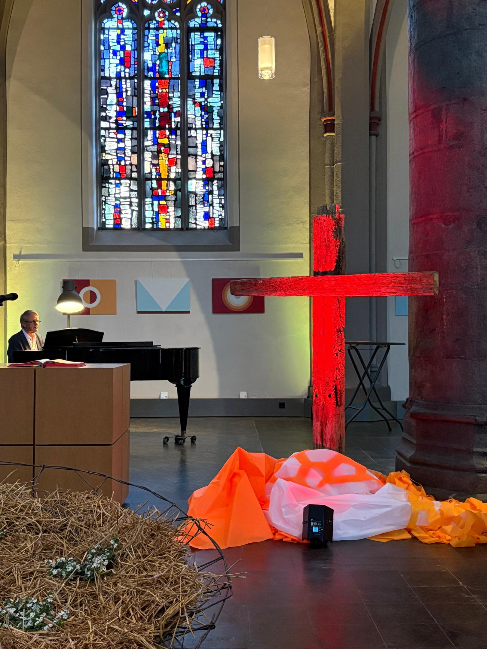 Der Fuß des Holzkreuzes im Zentrum der Citykirche ist von den Tüchern der vorangegangenen Ausstellung bedeckt. (c) Garnet Manecke