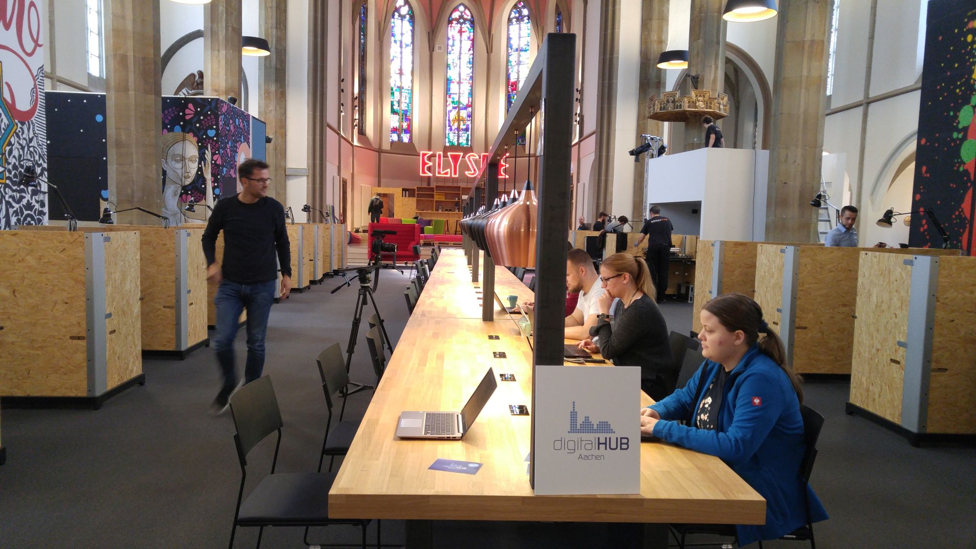 Gearbeitet wird unter anderem an einer langen Tafel mit flexiblen Arbeitsplätzen, mittig im Kirchenschiff. (c) Digital Hub Aachen