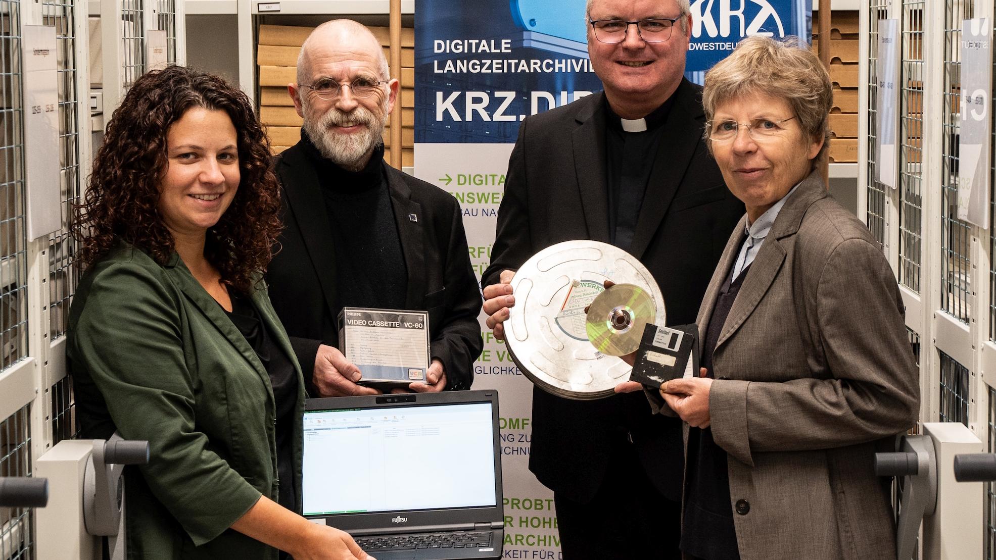Statt auf Filmrollen, DVDs oder Disketten sind die Daten nun langfristig gesichert:  Julia Haberstock (v. l.), Reiner Weick, Generalvikar Jan Nienkerke und Beate Sophie Fleck freuen sich über diesen wichtigen Schritt. (c) Bistum Aachen/Christian van‘t Hoen