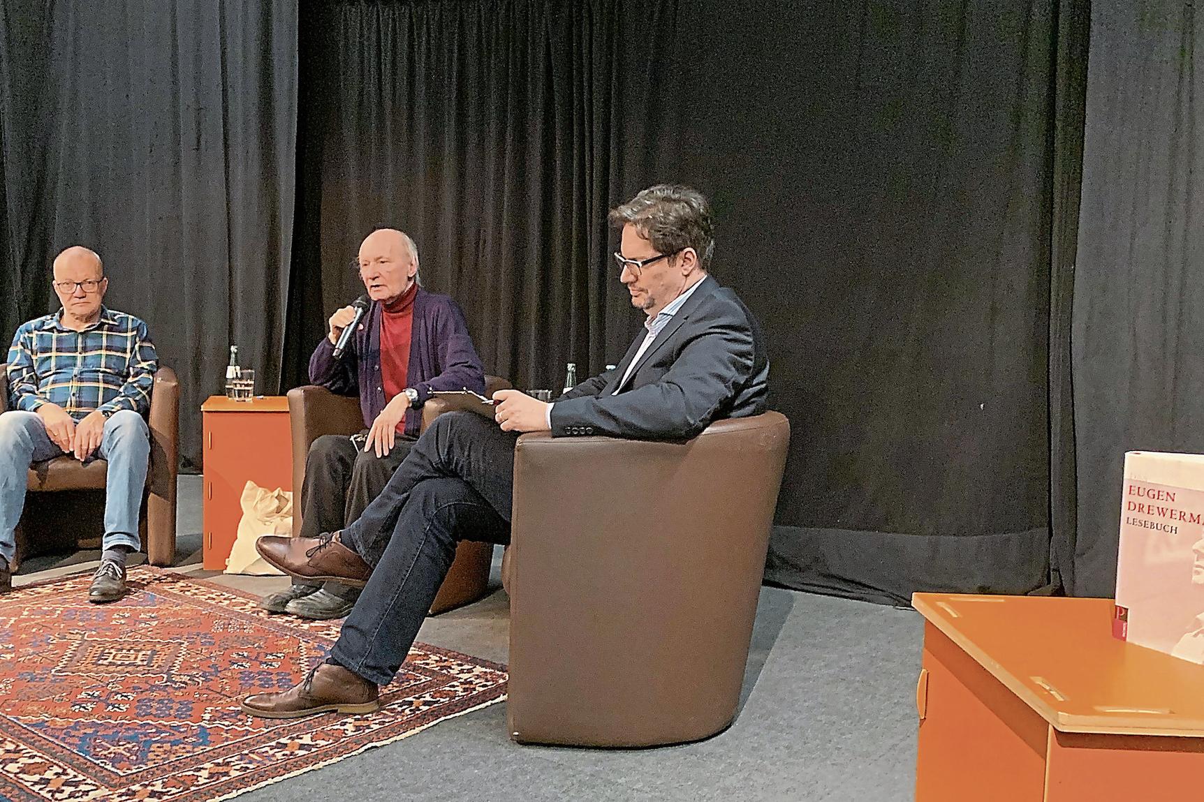 Eugen Drewermann (M.) stellt im Theatersaal des Kaiser-Karl-Gymnasiums, flankiert von Heribert Körlings (l.) und Christian Kraus seine Ansichten dar.
