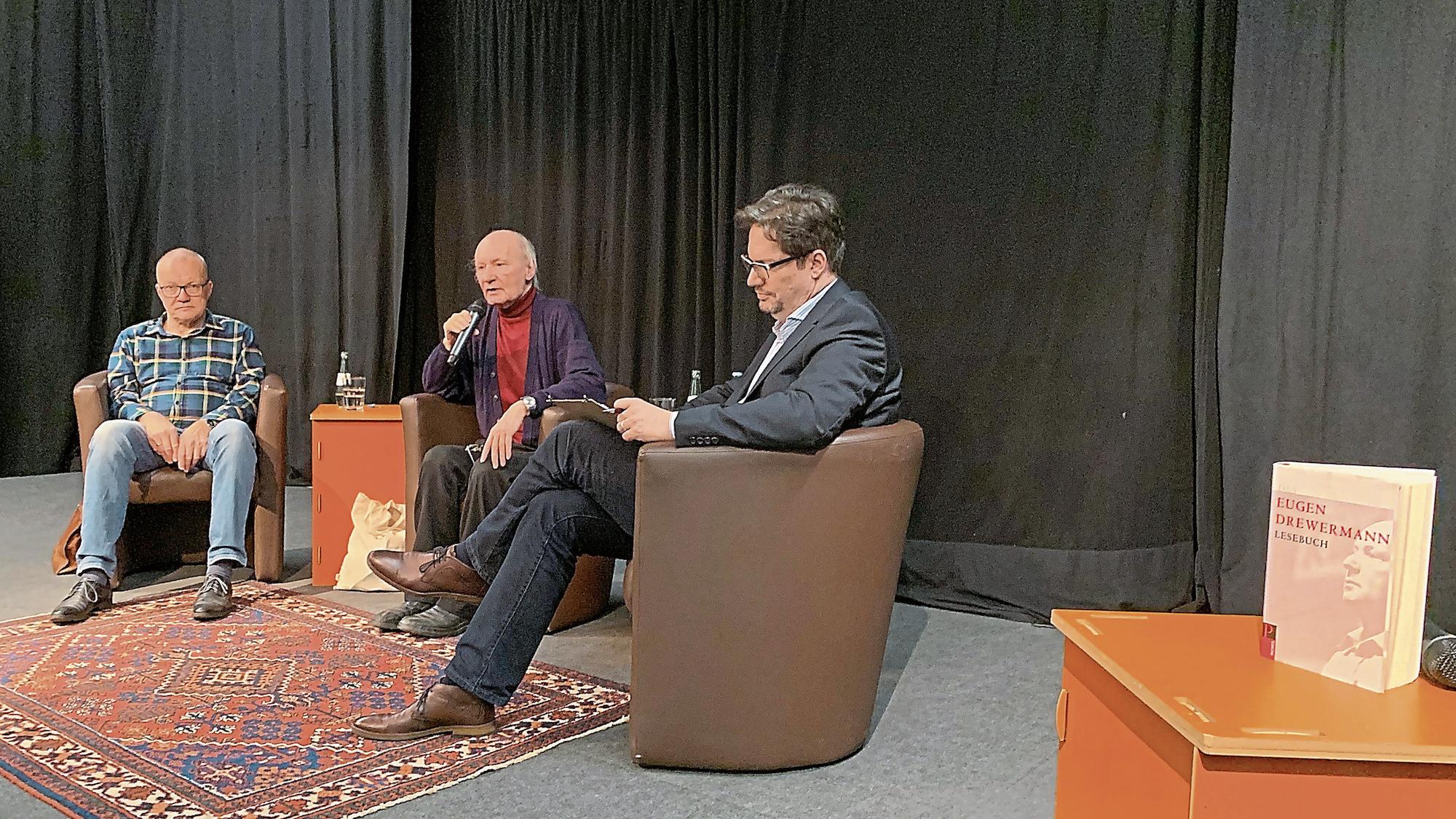 Eugen Drewermann (M.) stellt im Theatersaal des Kaiser-Karl-Gymnasiums, flankiert von Heribert Körlings (l.) und Christian Kraus seine Ansichten dar. (c) Benedikt Grzeschik