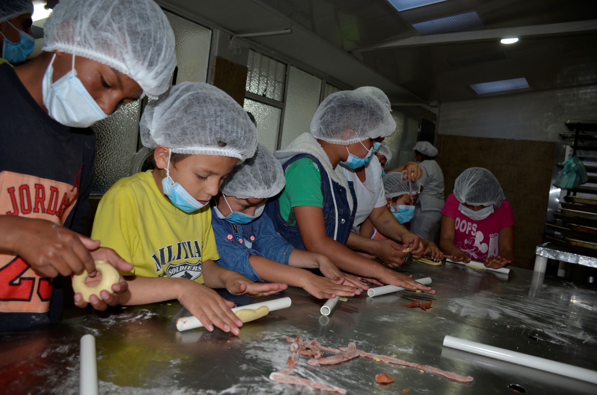 Alberto (2.v.l.) will später  einmal Bäcker werden. Schon jetzt backt er mit Leidenschaft Plätzchen. (c) Aktion Friedensdorf