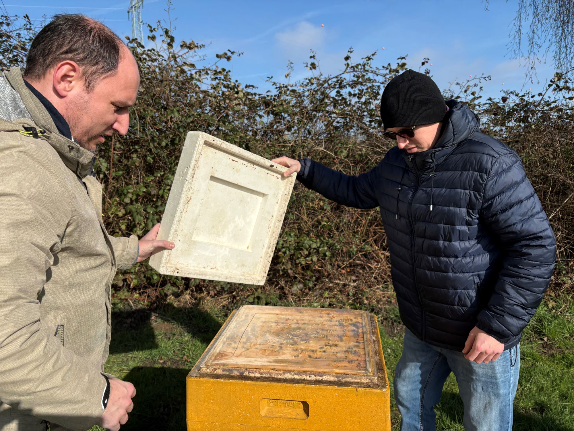 Felix (l.) und Florian Vitz heben den Deckel der Zarge, um zu schauen, wie es dem Bienenvolk geht. (c) Garnet Manecke