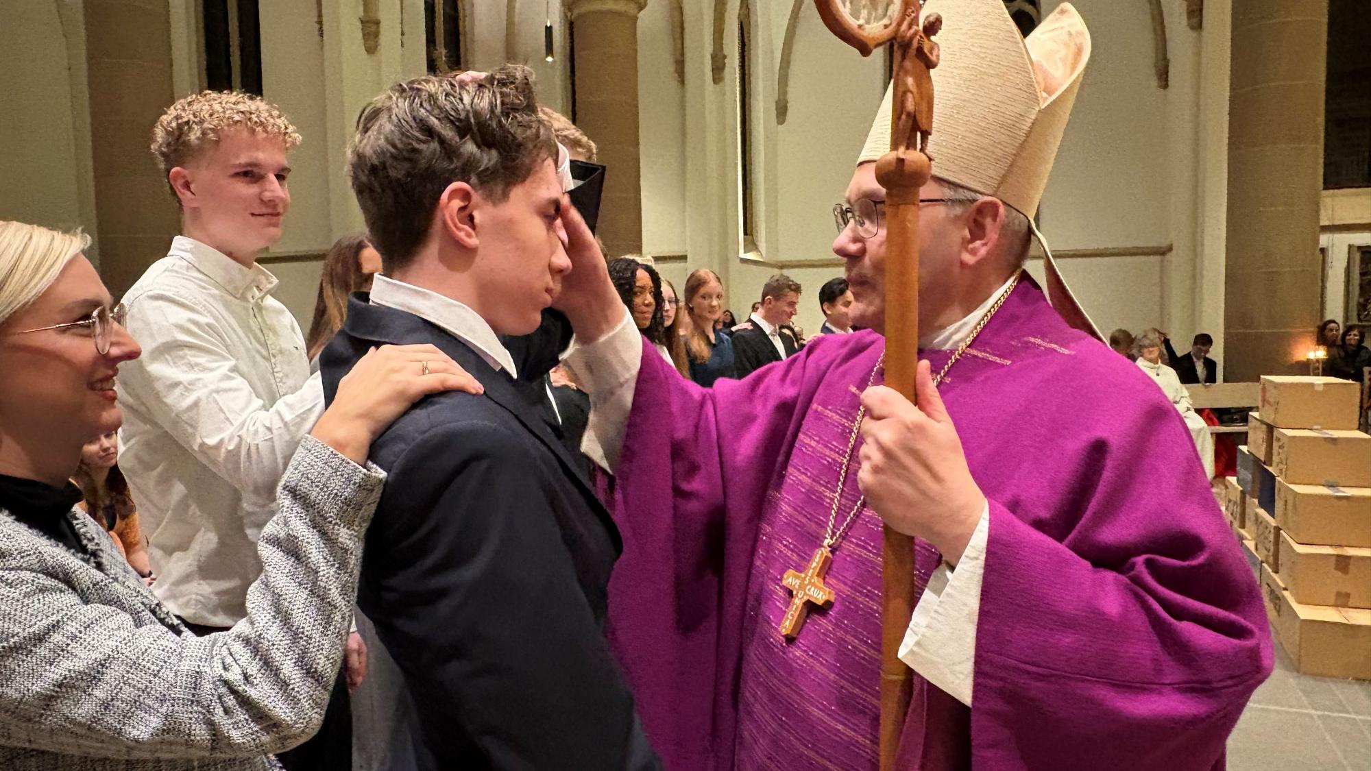 Bischof Helmut Dieser spendet einem Jugendlichen das Sakrament der Firmung. (c) Garnet Manecke