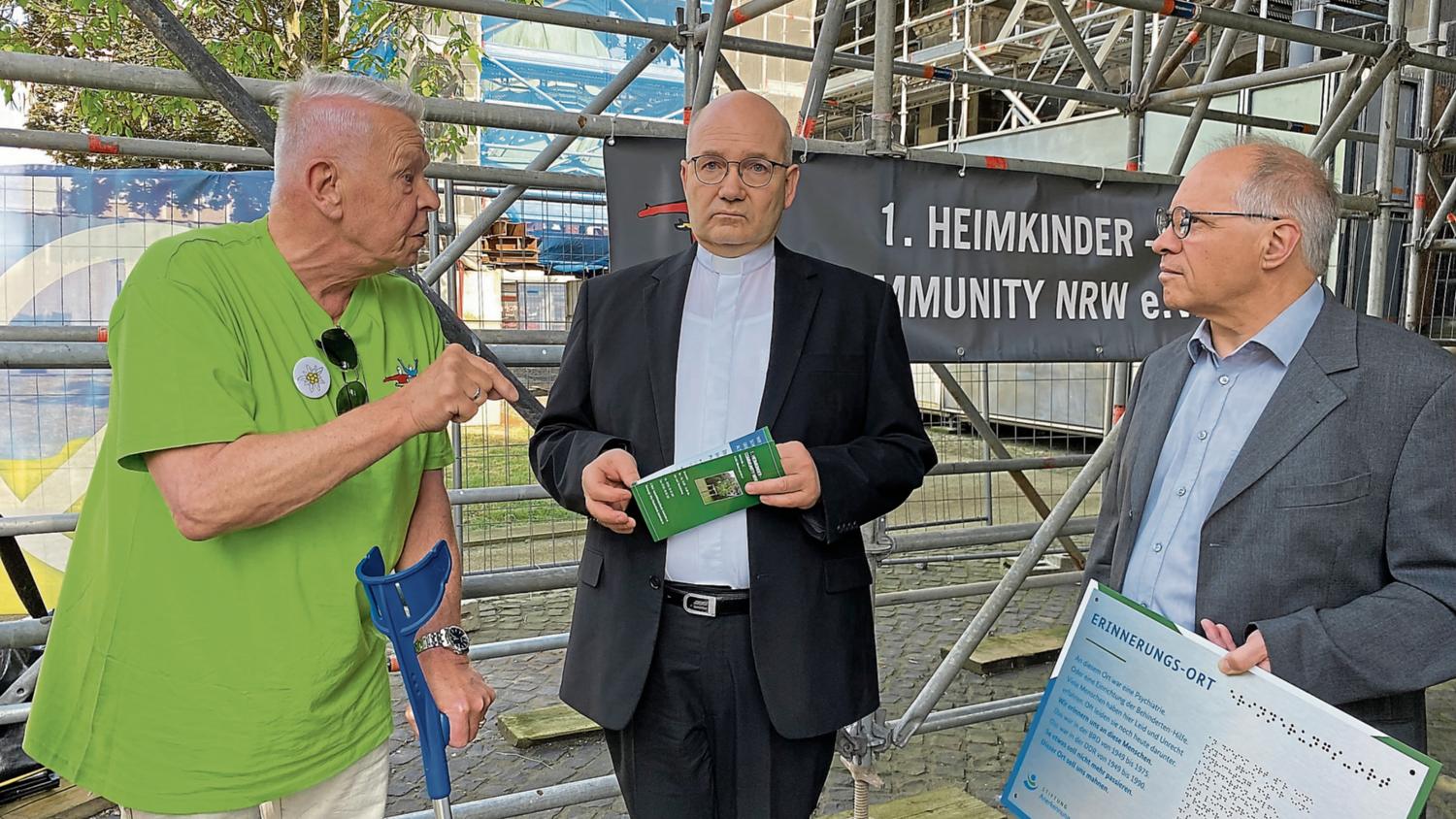 Uwe Werner, Vorsitzender der 1. Community ehemaliger Heimkinder, sprach mit Bischof Helmut Dieser und Münsterpropst Peter Blättler (v. l.). (c) Garnet Manecke