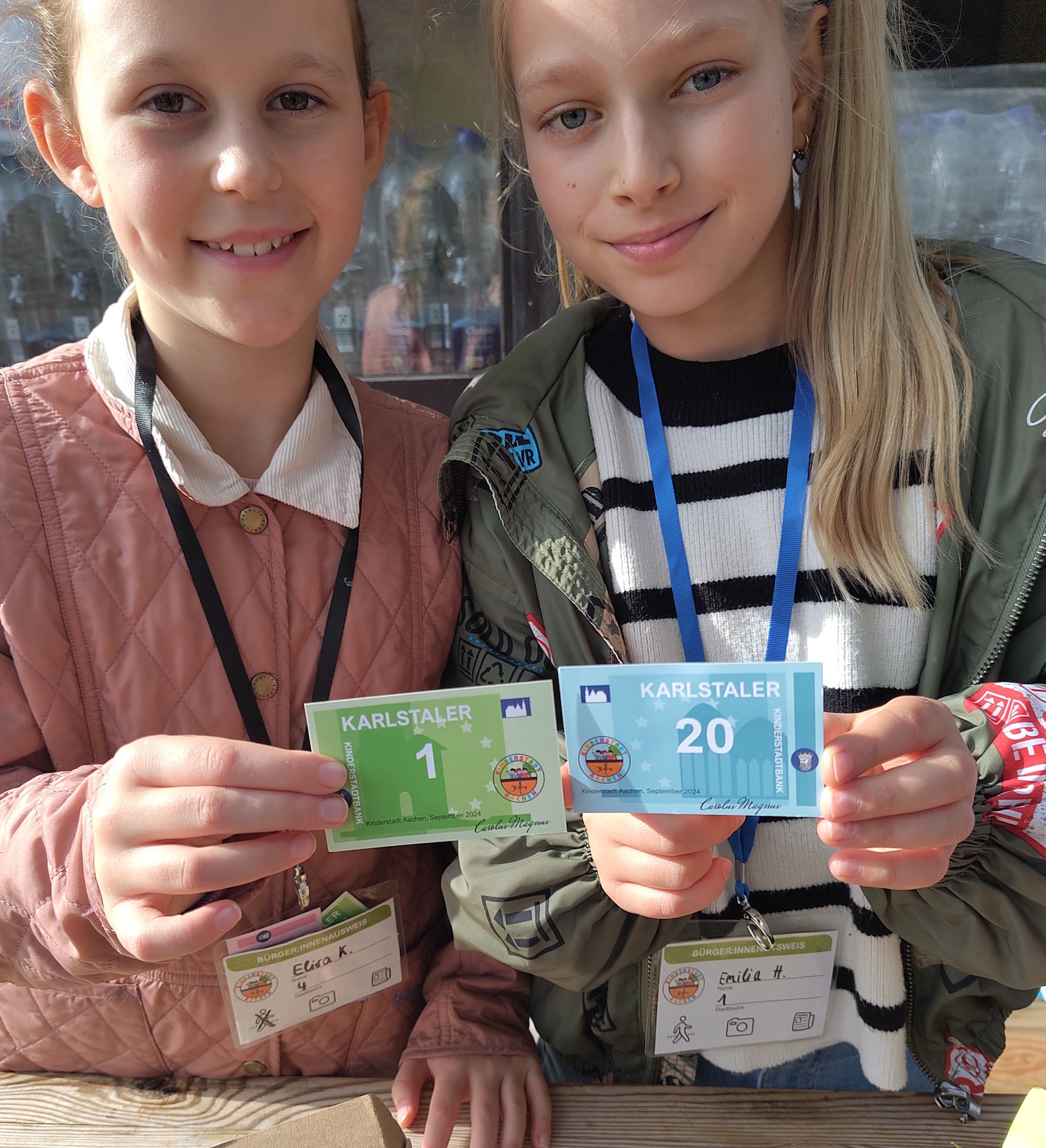 Die Kinderstadt hat auch eine eigene Währung, Elisa (l.) und Emilia zeigen den Karlstaler. (c) Kathrin Albrecht