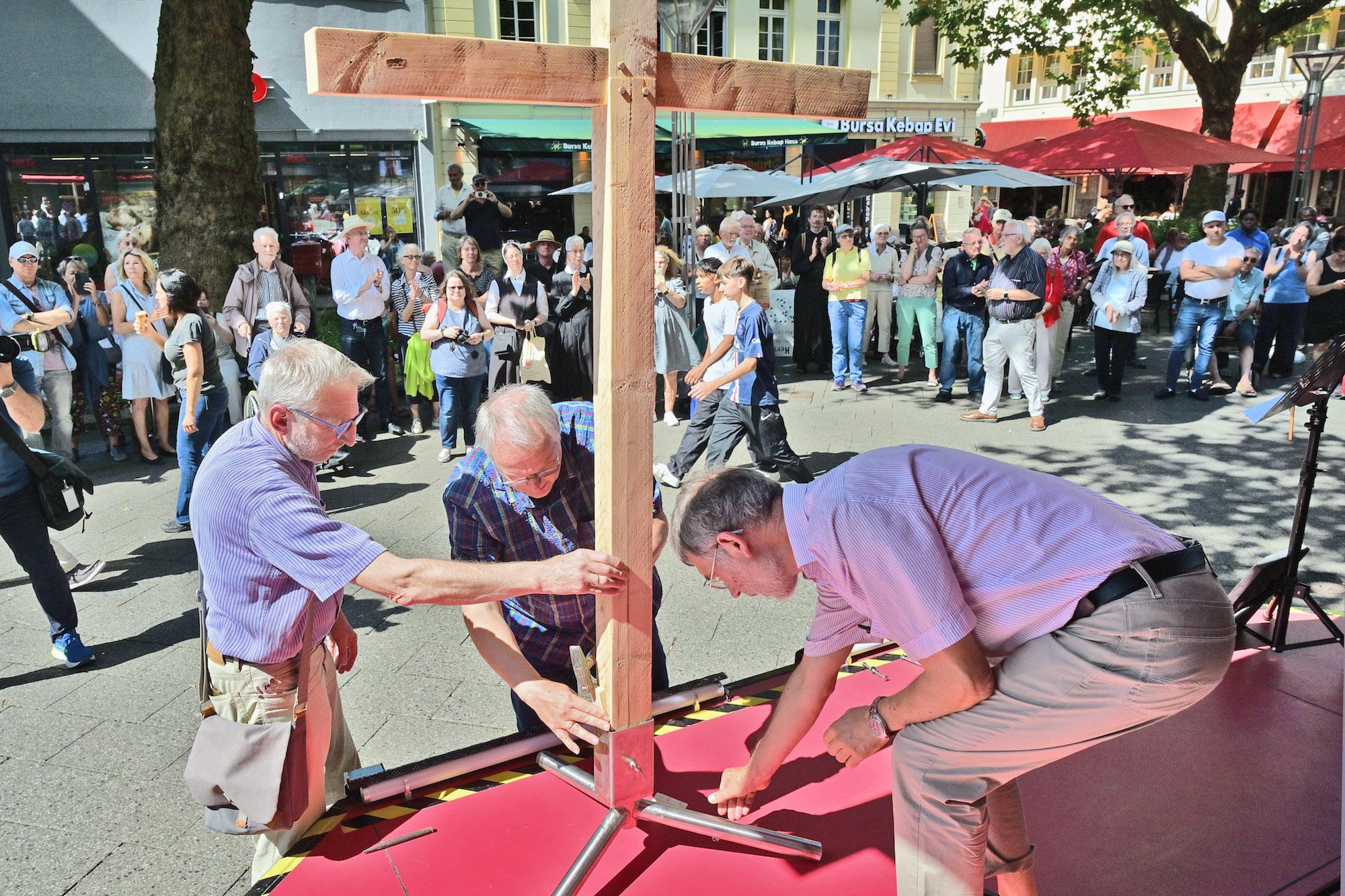 Auf dem Neumarkt werden die vier Kreuzteile, die die Teilnehmer der vier Wallprozessionen getragen haben, zusammengesetzt.