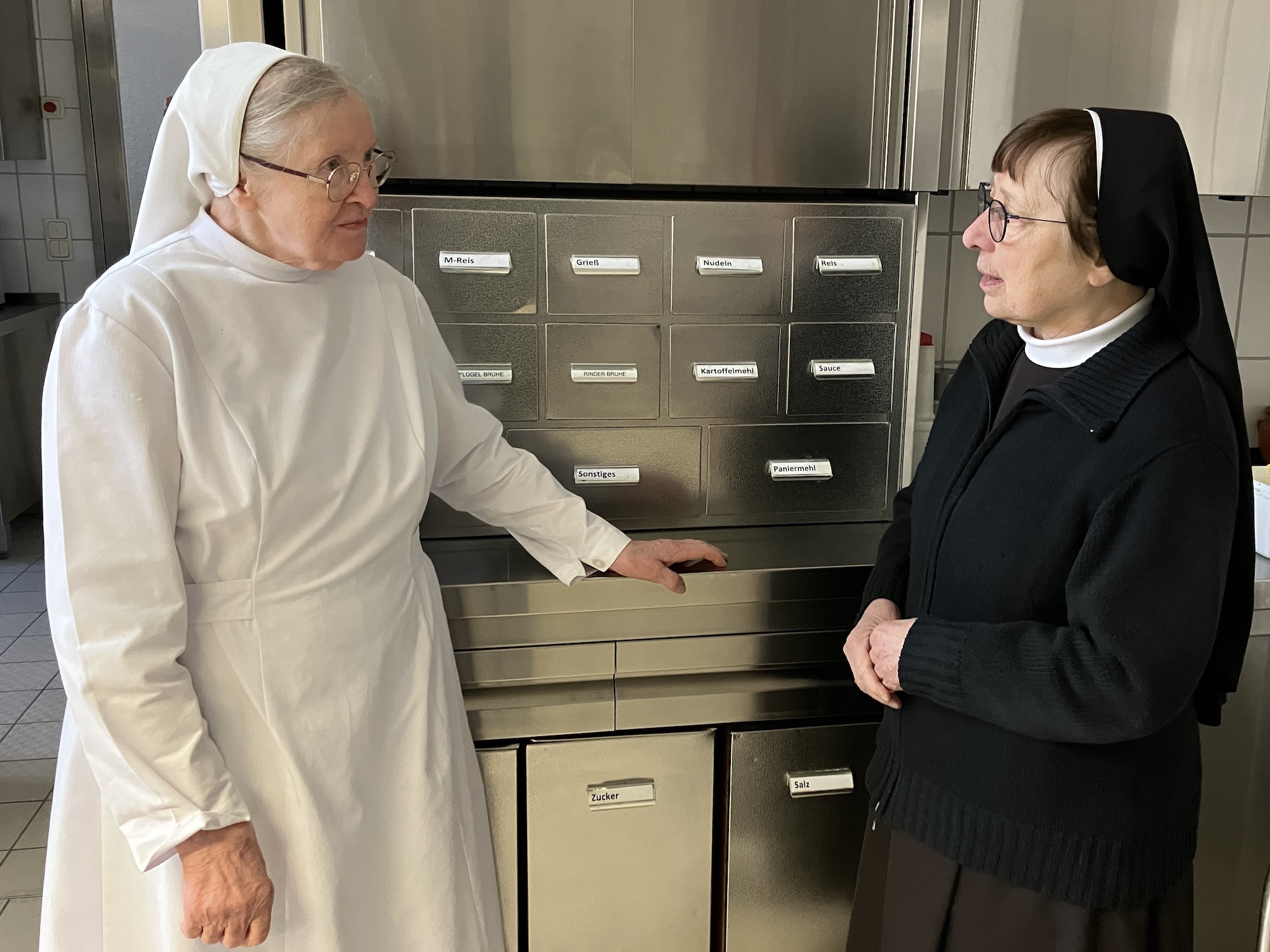 Schwester Susanne (r.) im Gespräch mit Schwester Roselind, die in der Küche nicht nur für die Plätzchen, sondern auch das Weihnachtsessen verantwortlich ist. (c) Andrea Thomas