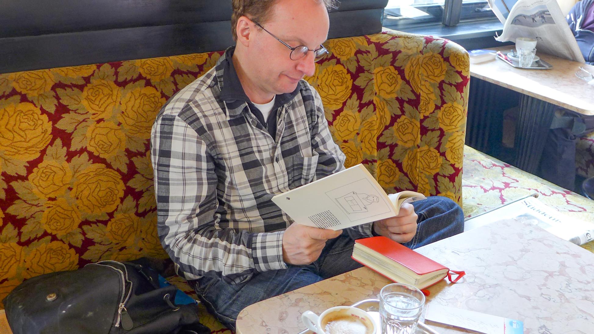 Auch im Café ist das „Nebenhirn“ in Form des roten Notizbuchs immer an der Seite von Marcell Feldberg. (c) privat