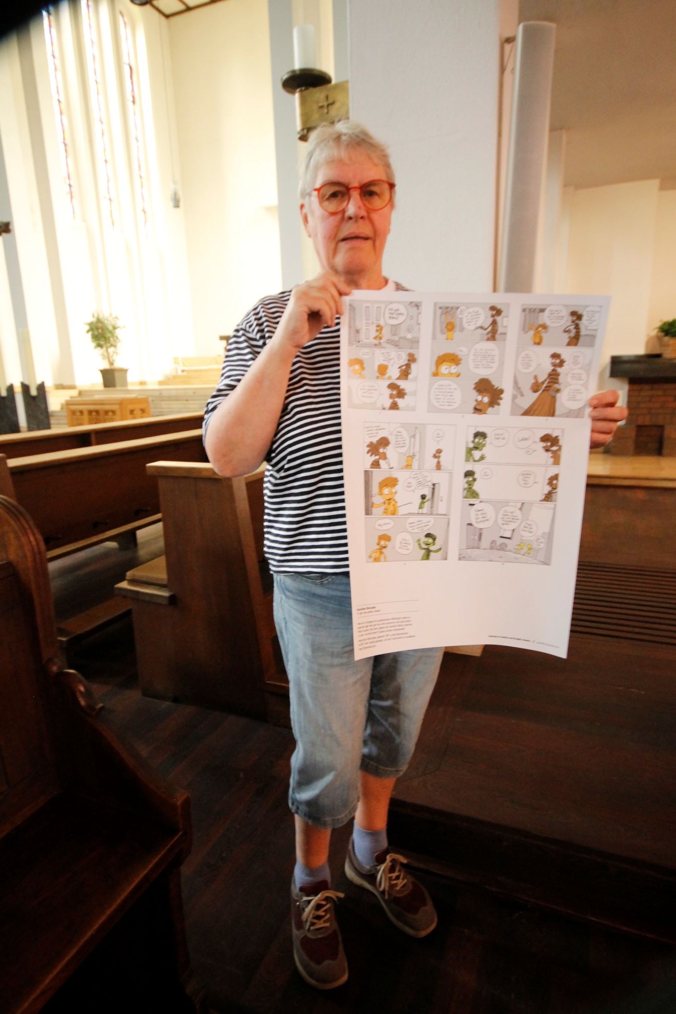 Die Kirche Herz Jesu zeigt eine Ausstellung. Barbara Mellenthin zeigt eines der Plakate. (c) Kathrin Albrecht