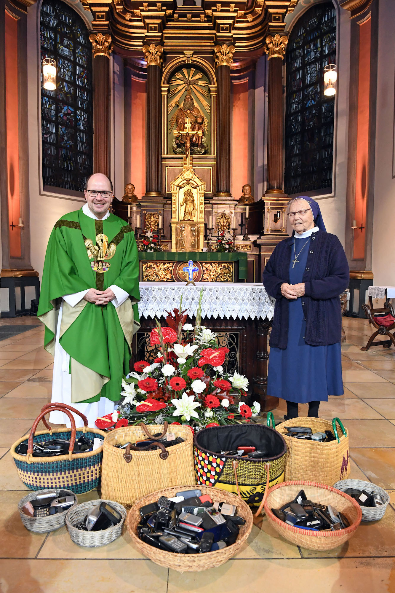 Zum ersten Mal gab es im Gottesdienst eine Handy- Kollekte. Missio-Präsident Dirk Bingener und Schwester Angelina freuen sich über das gute  Ergebnis. (c) Andrea Thomas