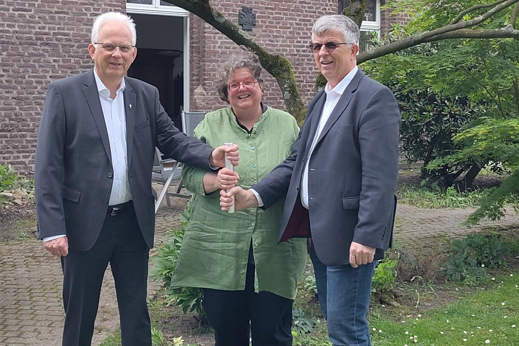 Als Team in der Region unterwegs: Propst Thomas Eicker (l.), Gabi Terhorst und Harald Hüller. Symbolisch teilen sie sich einen Staffelstab.