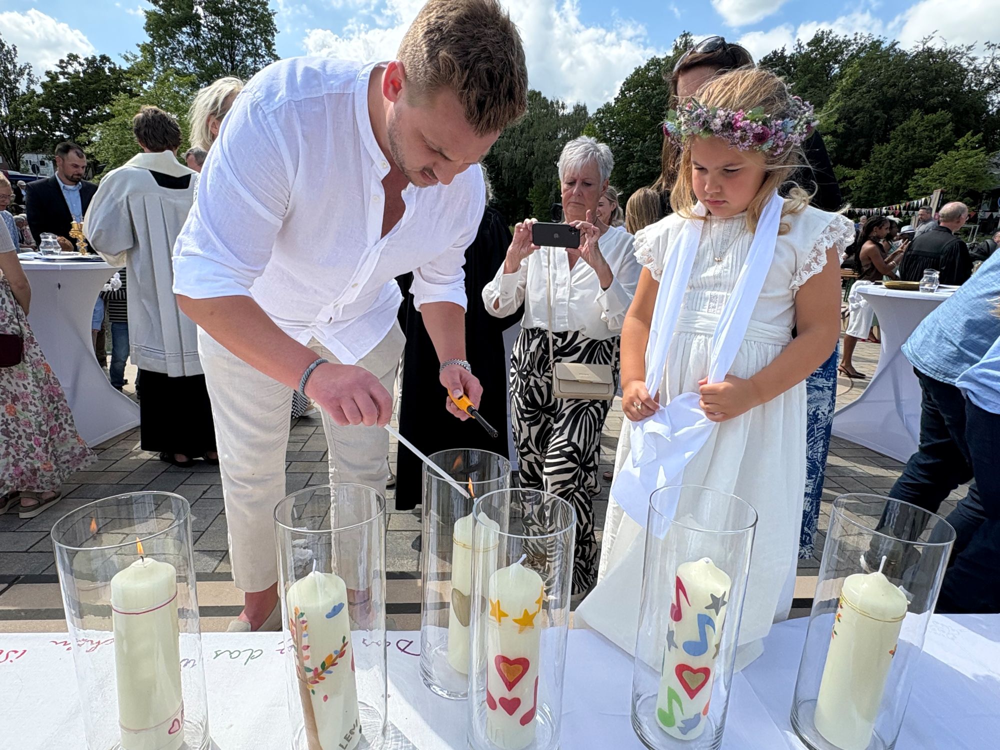 Loua entzündet mit Hilfe ihres Vaters ihre Taufkerze. (c) Garnet Manecke