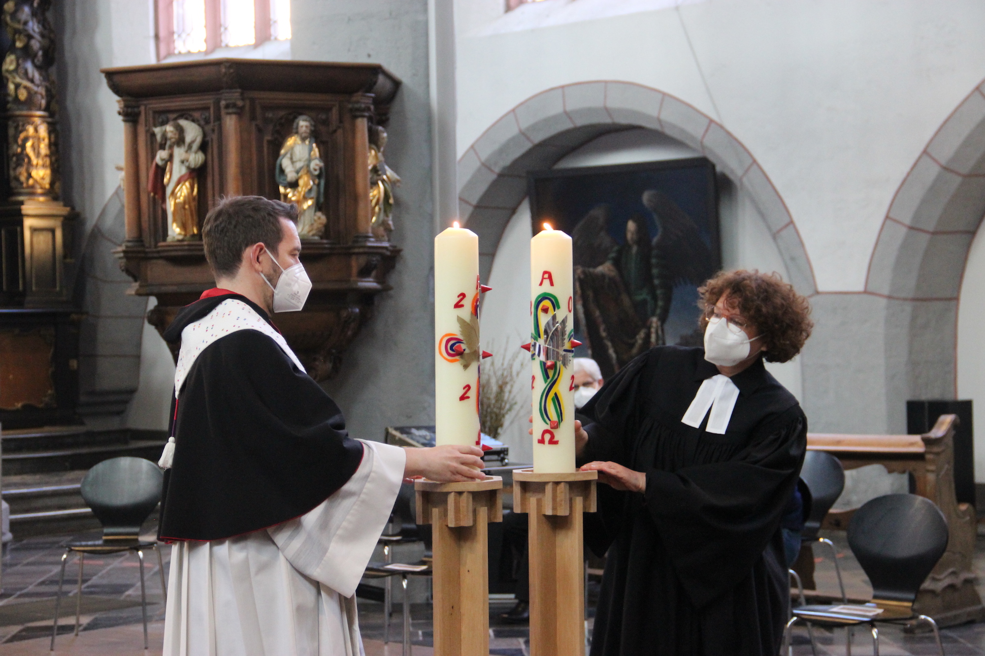 Pfarrer Matthias Fritz (KHG) und Pfarrerin Swantje Eibach-Danzeglocke (EHG) setzen die Kerzen auf die neuen Leuchter.