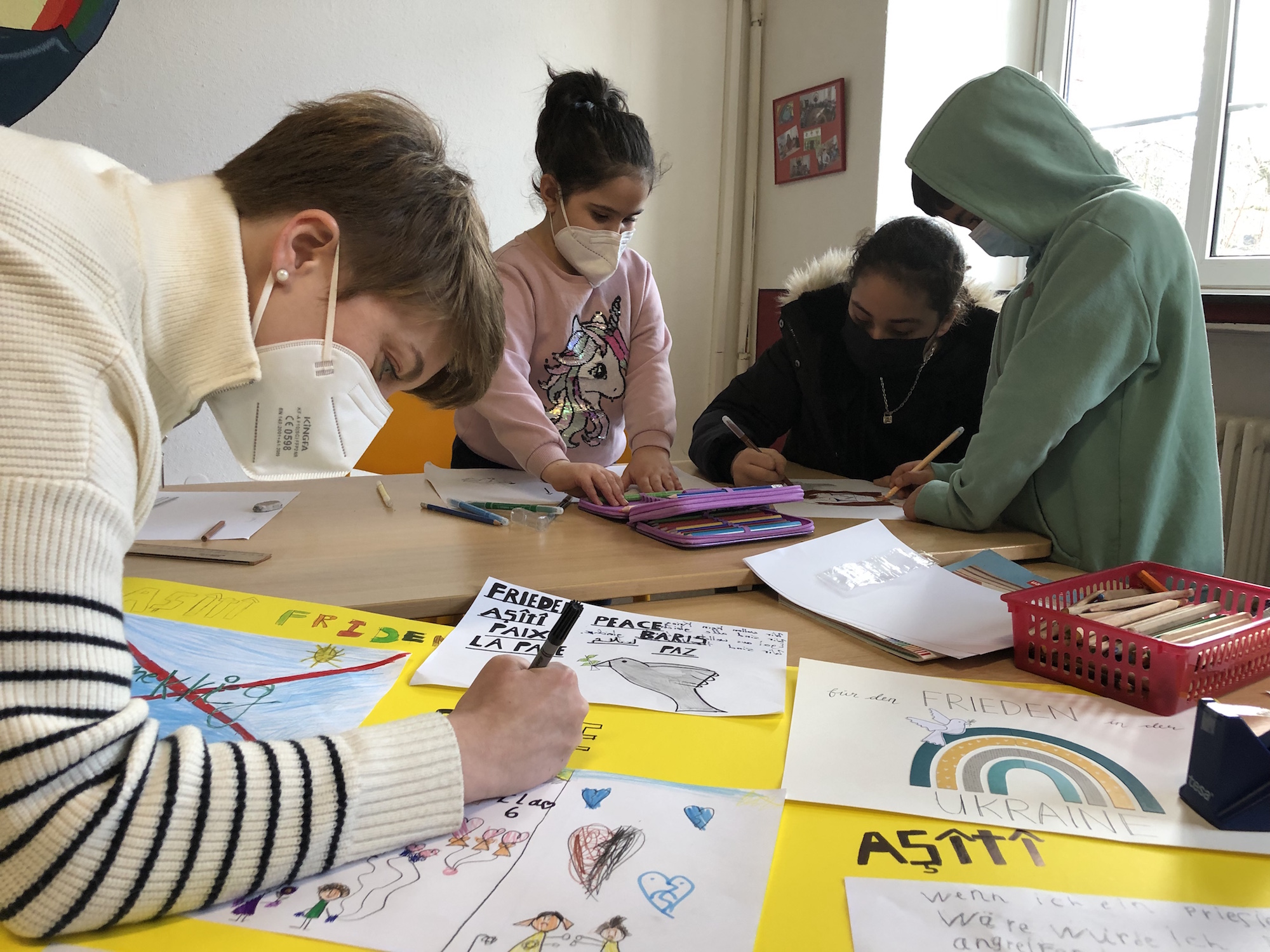 Gemeinsam malen und schreiben die Kinder ihre Botschaft auf Plakate. Sie wollen  Frieden. (c) Garnet Manecke