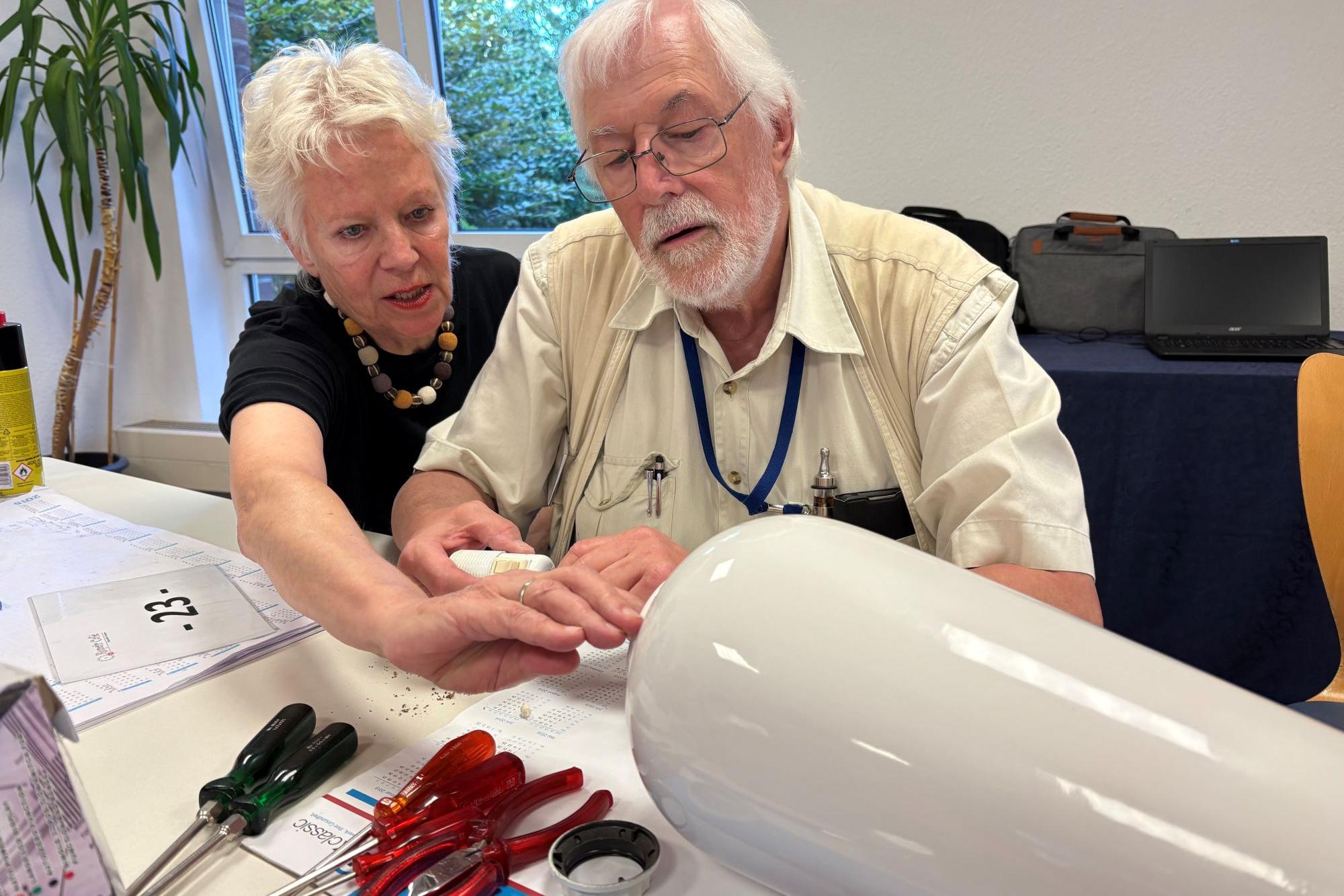 Eva Schneider hat eine Lampe mitgebracht, die Gangolf Gerighausen repariert.