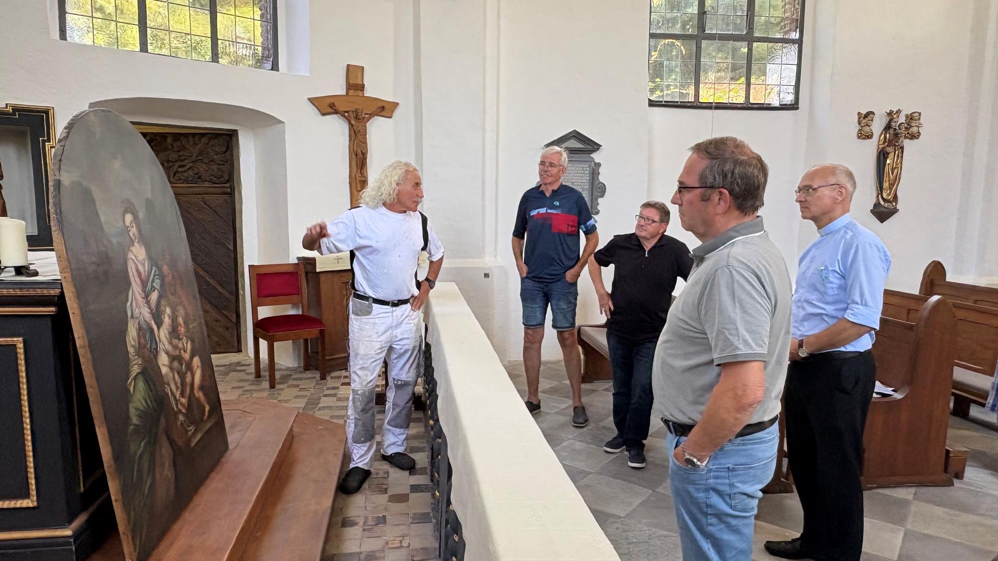 Kirchenmaler Norbert Seidel erklärt Karl-Heinz Roehlen, Josef Schnock, Wolfgang Esser und Marc Zimmermann die Arbeiten an dem Altarbild. (c) Garnet Manecke