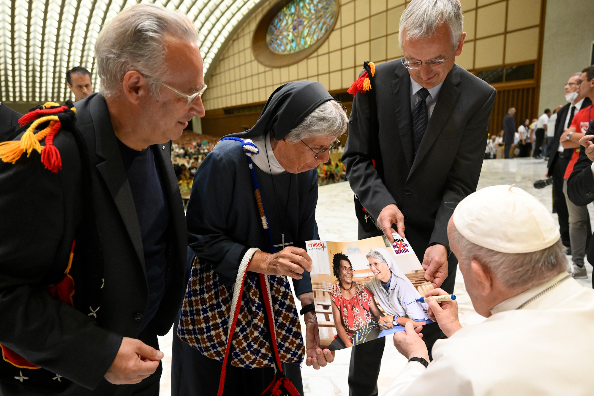 Anfang August erhielt Schwester Lorena eine Audienz bei Papst Franziskus, um ihr Projekt vorzustellen. Papst Franziskus signiert das Kampagnen-Foto, das sie und Christina zeigt. (c) Simone Risoluti/Vatican Media