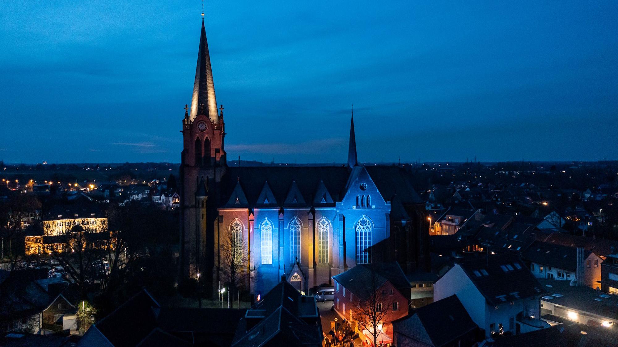 Beim 1. Jüchener Friedensmahl im März 2022 erstrahlte die Kirche St. Jakobus der Ältere in blau-gelb. (c) Michael Breuer