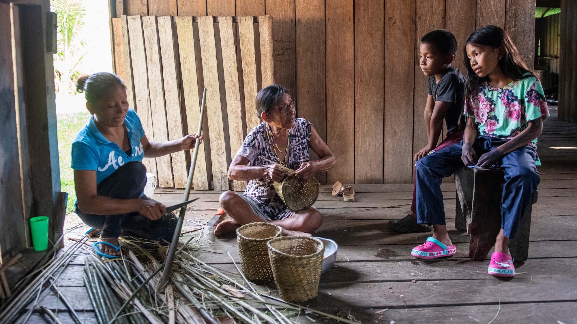 Von Oma Juana und ihrer Mutter Graciela (l.) lernt Valeria, Körbe aus getrockneten Palmblättern zu flechten. (c) Florian Kopp/Kindermissionswerk